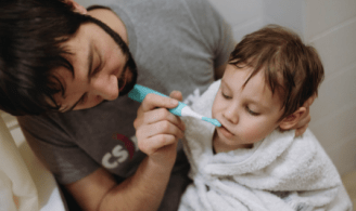 Father brushing his toddler's teeth, brushing every age.