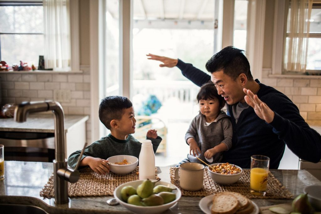 Father with two children eating breakfast. Teeth-friendly eating habits.